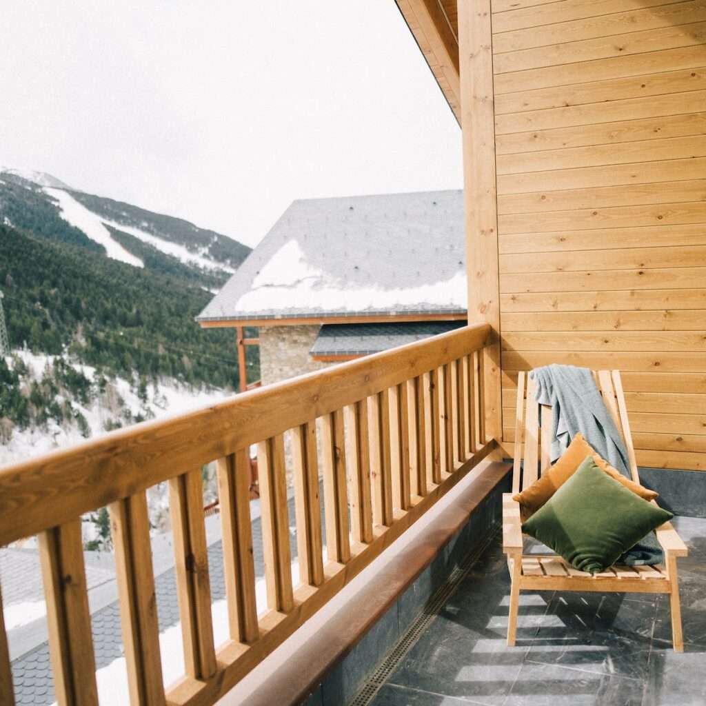 brown wooden chair on a veranda with view of a snowy mountain